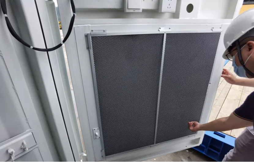 Hard hat worker by industrial door with wire mesh panels