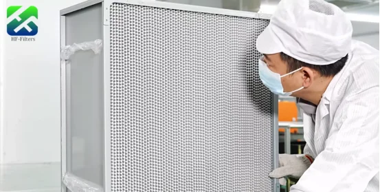 A worker in protective gear is carefully examining a large industrial air filter